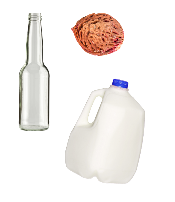 A clean glass bottle, A peach pit, and a milk jug with blue cap.