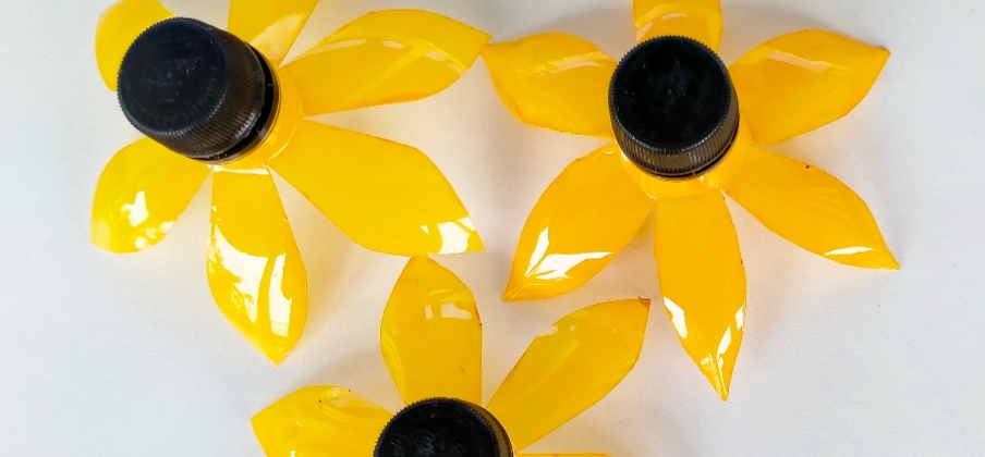 Three yellow flowers upcycled from plastic bottles.