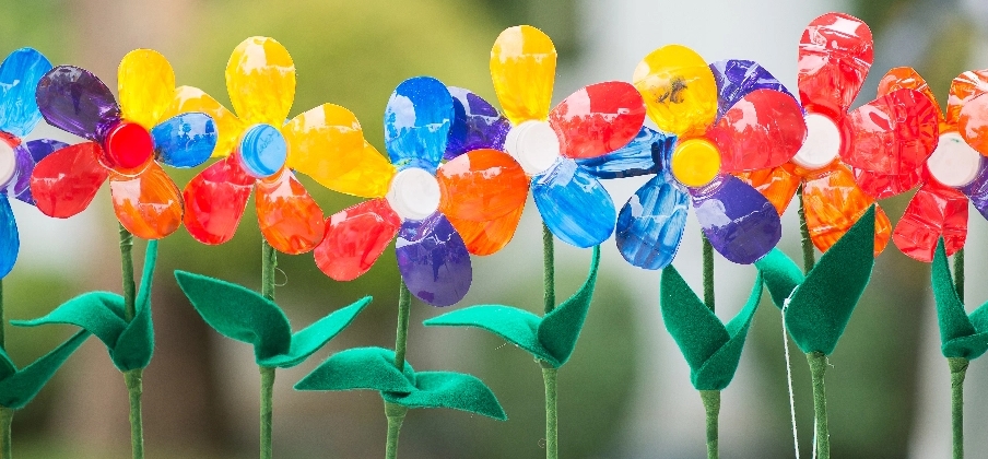 A line of colorful flowers with rainbow petals upcycled from plastic bottles.